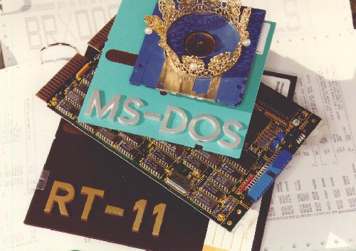 
 Symbolic still life of 
 an RT-11 floppy disk,
 the BAYDEL BRX50 board, 
 MS-DOS diskettes and
 a tiny crown 
 (50 Kbytes JPEG)
 Photo: MOSESelectronic
